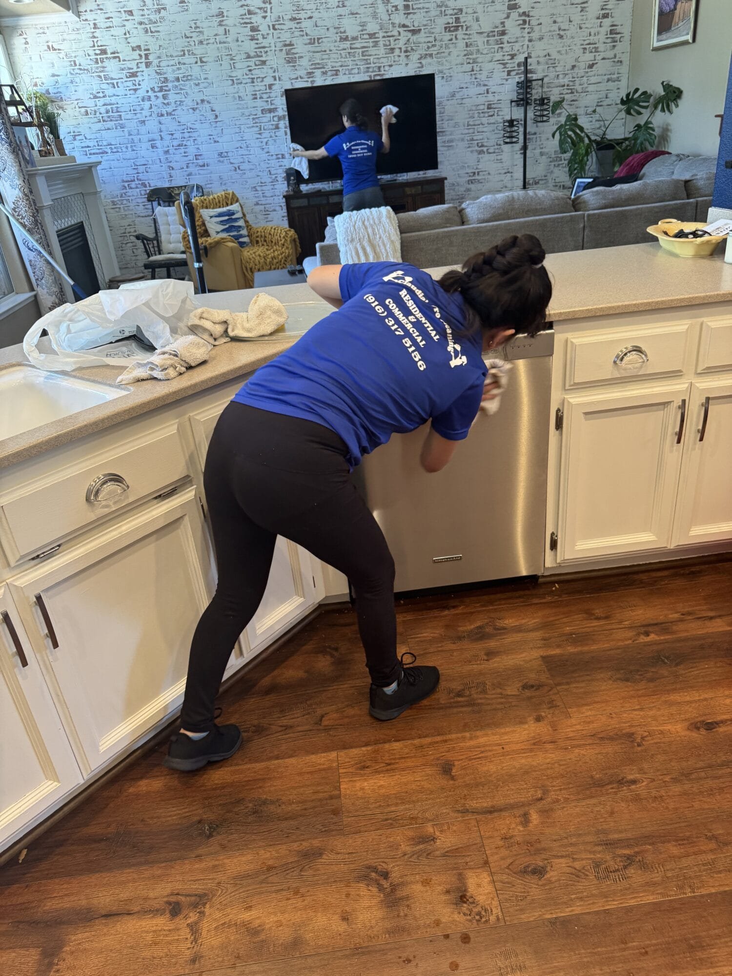 Professional kitchen cleaning service in Stockton CA cleaning cabinet exteriors and countertops during a detailed house cleaning service.