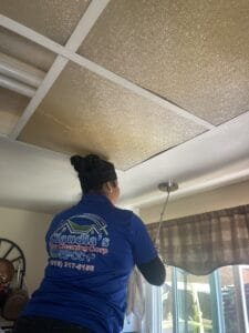 Professional post-construction cleaner wiping windows in Highland Hills, CA